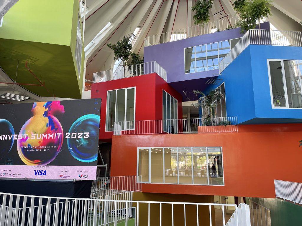 Tela do Innvest Summit 2023 dentro da colorida Pirâmide de Tirana