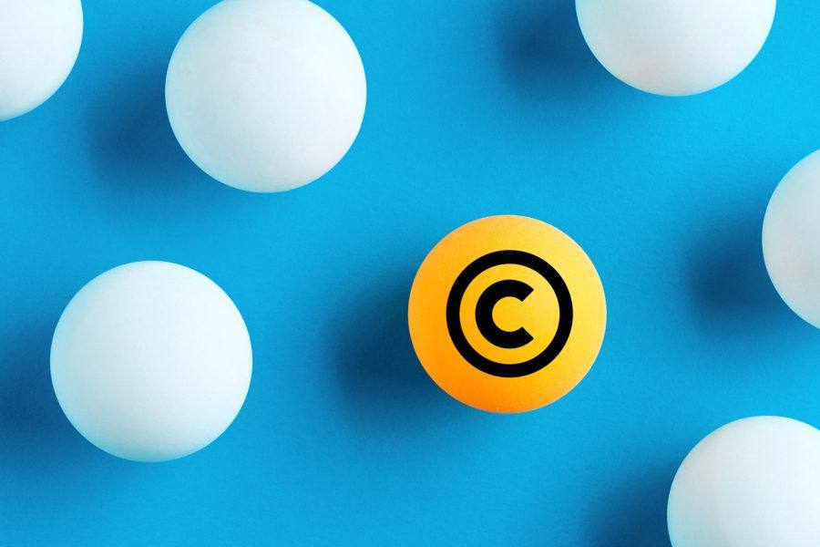 Bola laranja com o símbolo de copyright entre bolas brancas sobre fundo azul